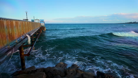 Puente-De-Madera-Que-Se-Extiende-Sobre-Las-Turbulentas-Aguas-Del-Mar-Azul.