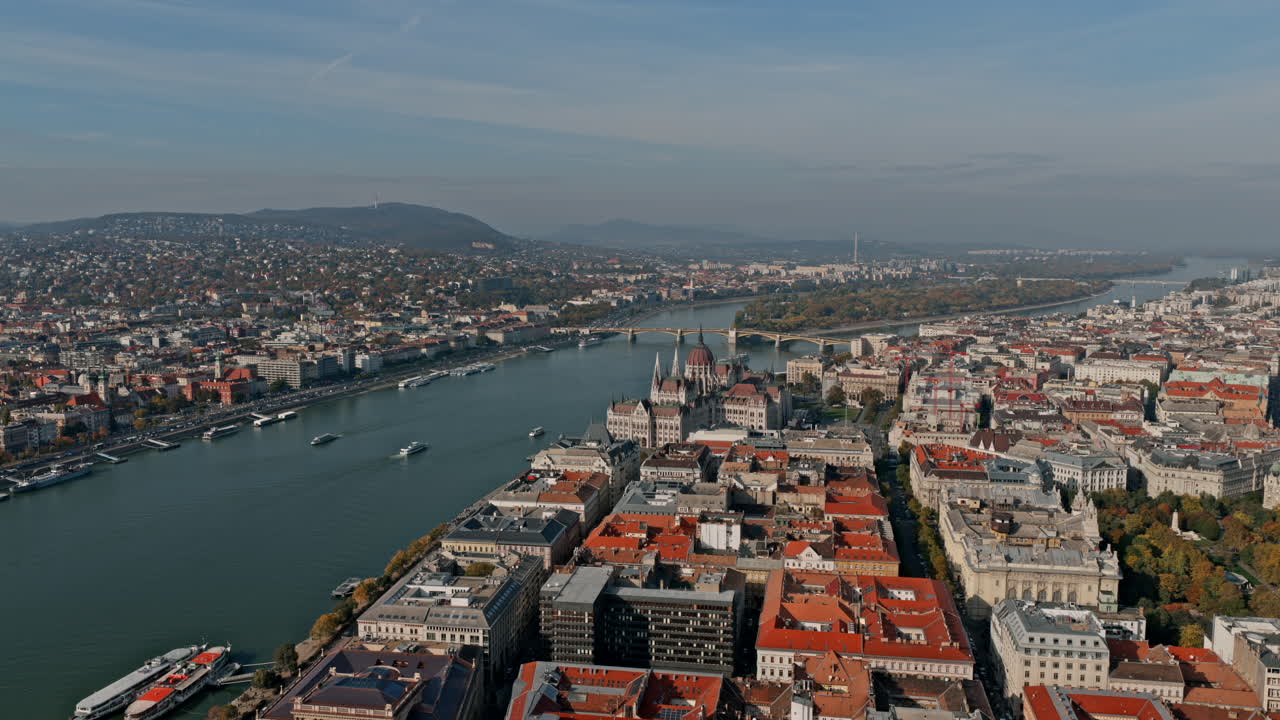 Veduta aerea diurna di Budapest che mostra il Parlamento lungo il Danubio e i ponti che collegano Buda e Pest sotto un cielo sereno