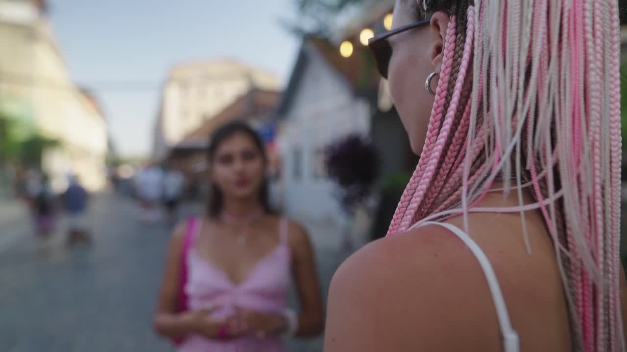 Two women chatting on a cobblestone street