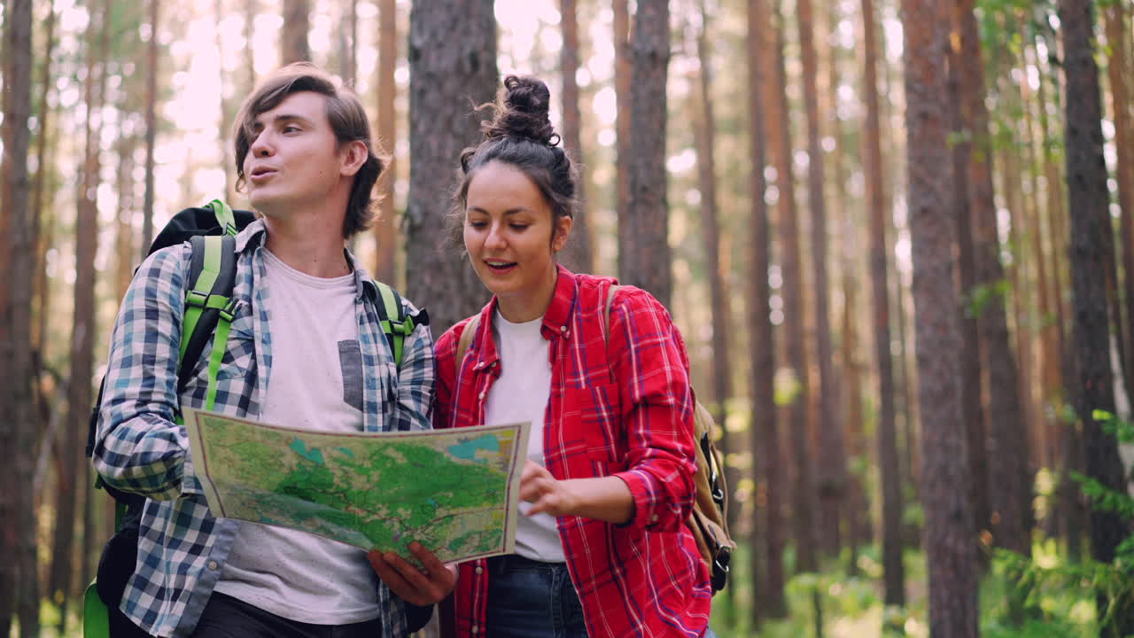 Couple Hiking in the Forest, Using a Map