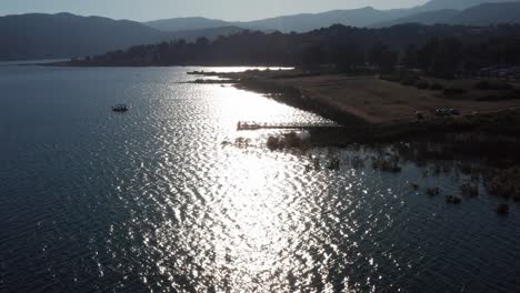 Nach-Oben-Neigende-Luftaufnahme-Von-Fischern,-Die-Auf-Einem-Kleinen-Dock-In-Lake-Casitas,-Kalifornien,-Silhouettiert-Sind