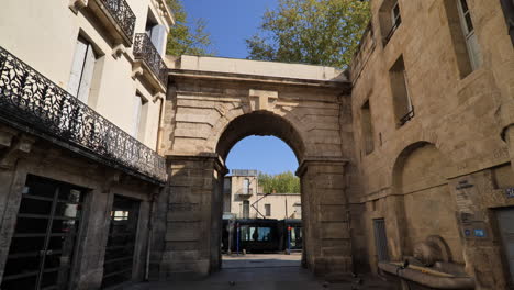 el tranvía pasa bajo un arco en montpellier.