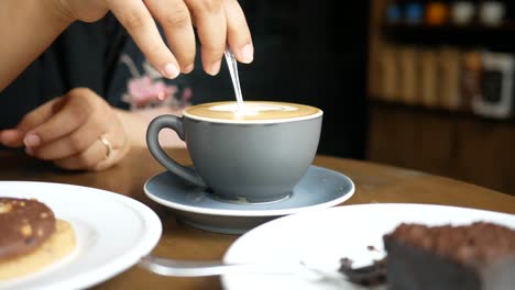 mujer disfrutando de café y postre en un café