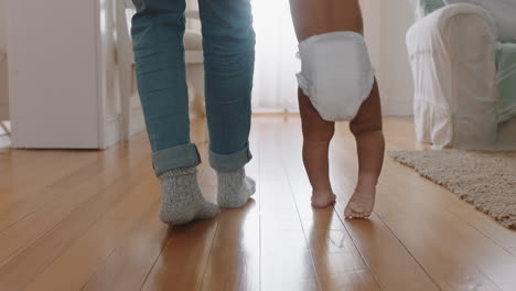 bebé aprendiendo a caminar niño pequeño dando sus primeros pasos con el padre ayudando al bebé enseñando al niño en casa