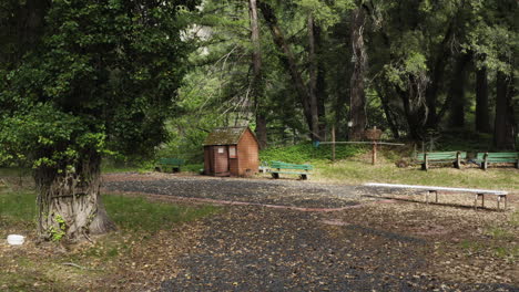 Piscina-Abandonada-En-Medio-Del-Bosque-Llena-De-Grava,-Muebles-Viejos-Todavía-En-Pie,-Concepto-De-Terror,-Muñeca-Aérea-En