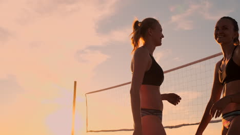 Two-young-girls-giving-high-fives-after-volleyball-match