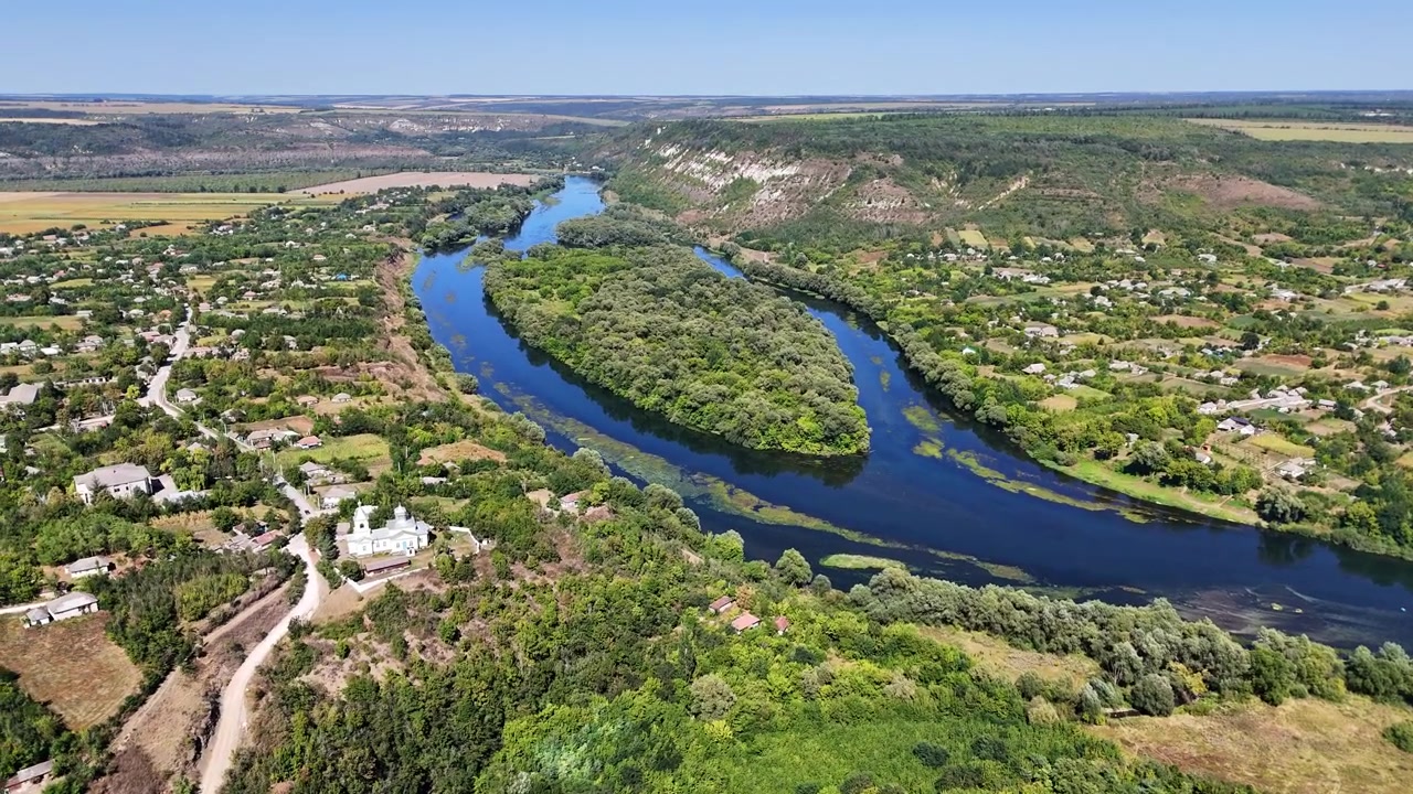 Dronebilde av en landsby med en hvit kirke ved bredden av Dnestr-elven under hvite kalksteinsklipper, Dnestr-elven, Moldova