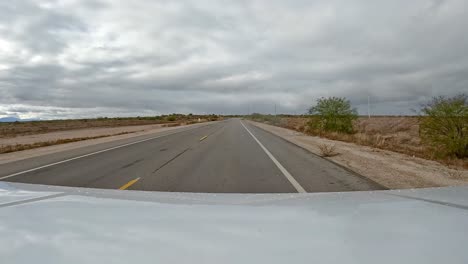 punto de vista - conduciendo en una carretera rural en el desierto de sonora en un día nublado en el sur de arizona