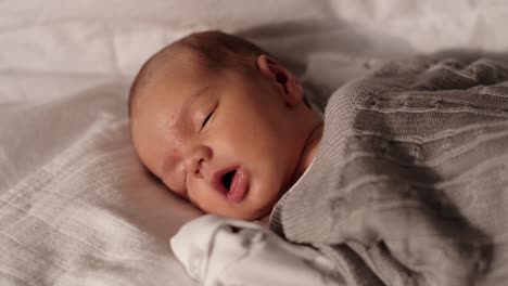cerca de la cara de un bebé recién nacido mientras duerme y respira fuertemente