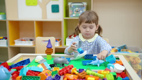 little girl plays with building lego blocks or bricks