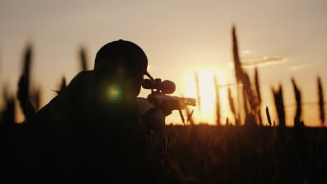 Ein-Scharfschützengewehr-Aus-Einem-Gewehr-Mit-Optischem-Visier-Auf-Das-Sportschießen--Und-Jagdkonzept-Bei-Sonnenuntergang