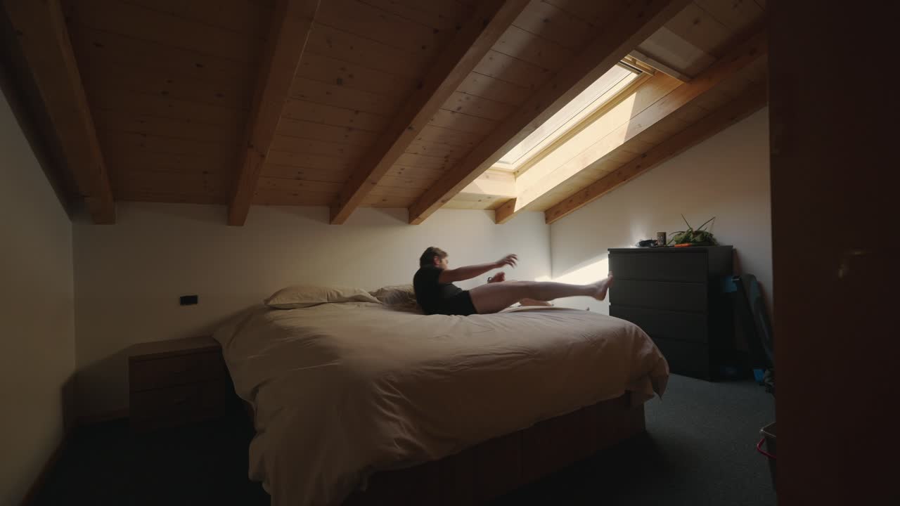 Uomo che si rilassa nella camera da letto in stile alpino con tetto in legno