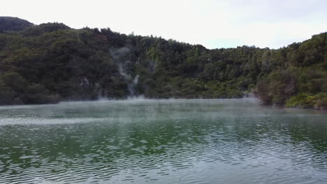 aerial shot of steaming blue lake in new zealand