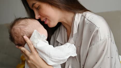 mother kissing infant and smiling