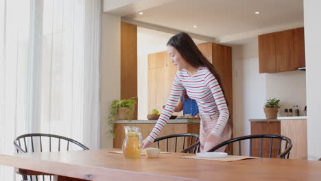 setting table with tea, young woman preparing meal in modern kitchen
