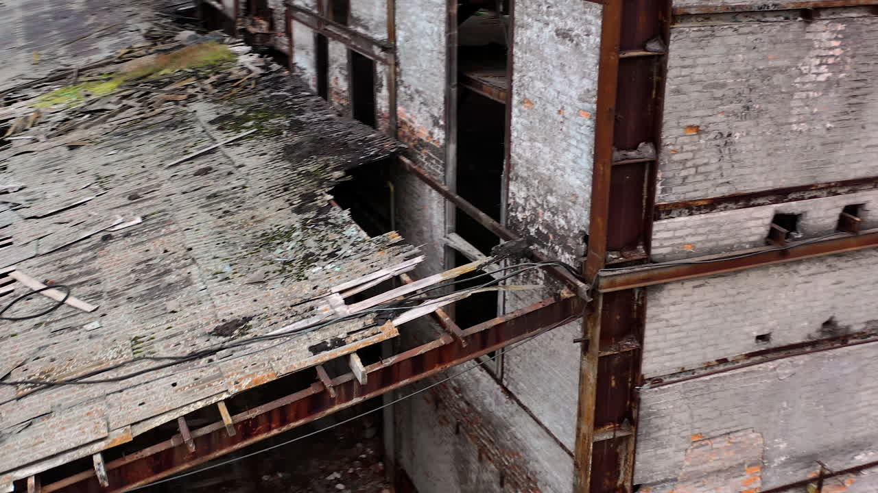Ruined building. Old architecture with broken windows and many holes in the walls. Exterior of damaged enterprise during military action. Close-up.