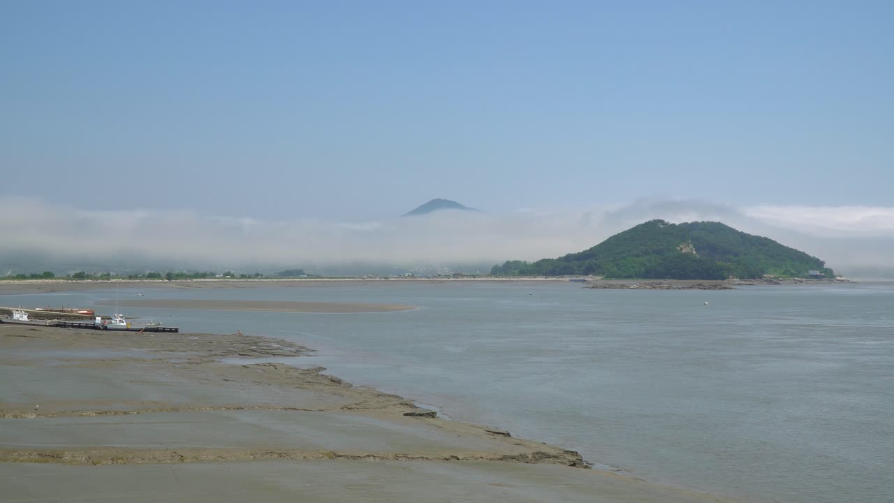 한국 강화도 섬의 썰물 때 진흙 속에 갇힌 어선들, 산봉우리 위의 안개와 수증기