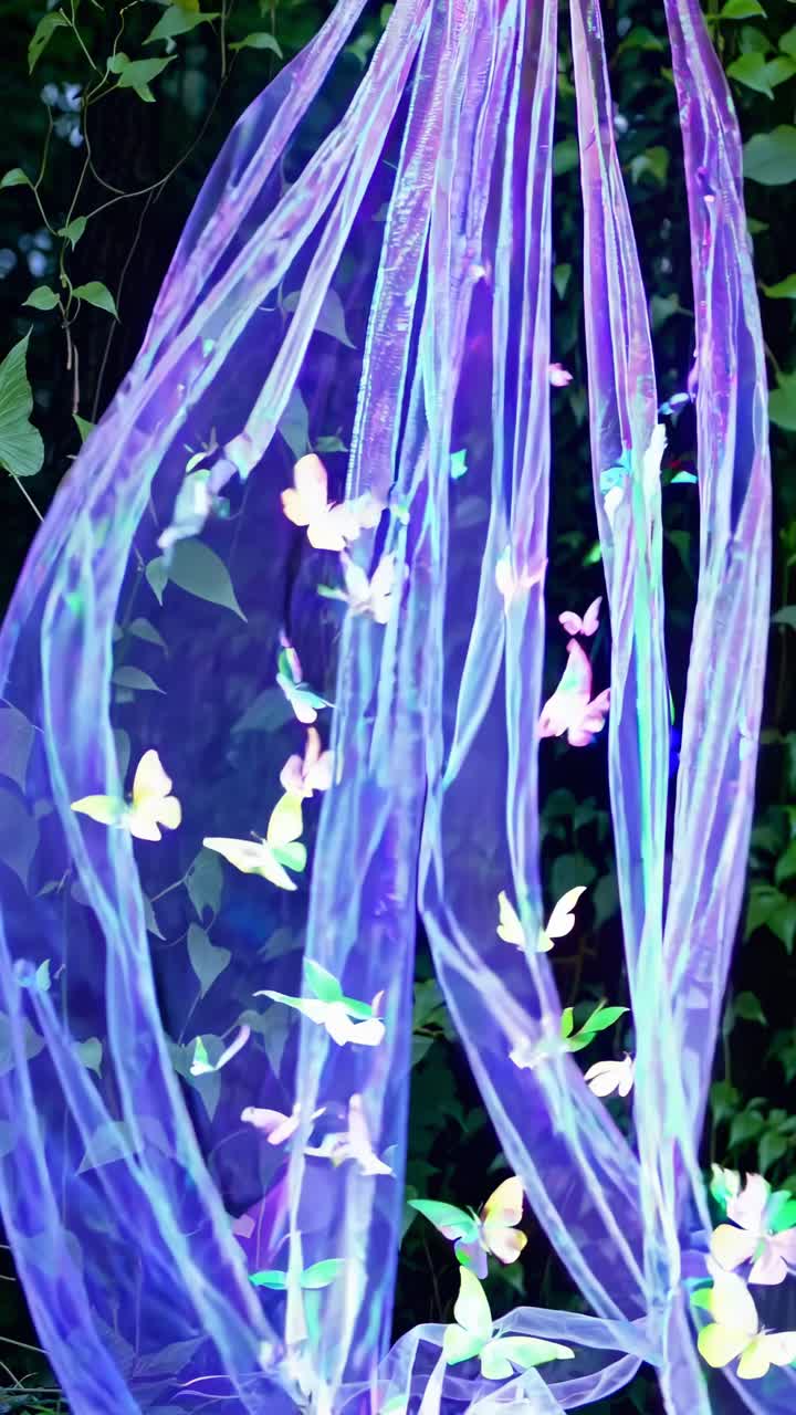 A dreamy video scene with glowing butterflies on sheer fabric, captured from a low angle