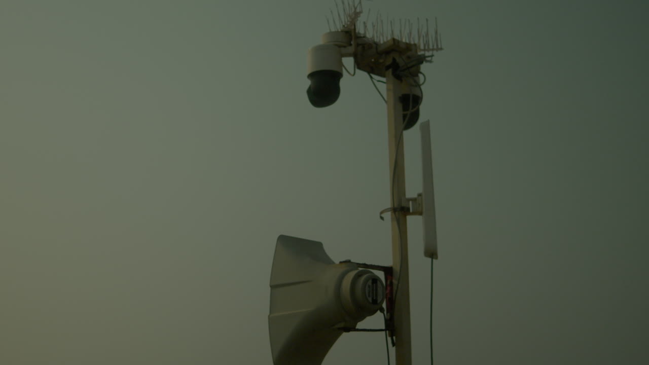 Torre di sorveglianza con telecamere su un cielo fosco, concetto di sicurezza