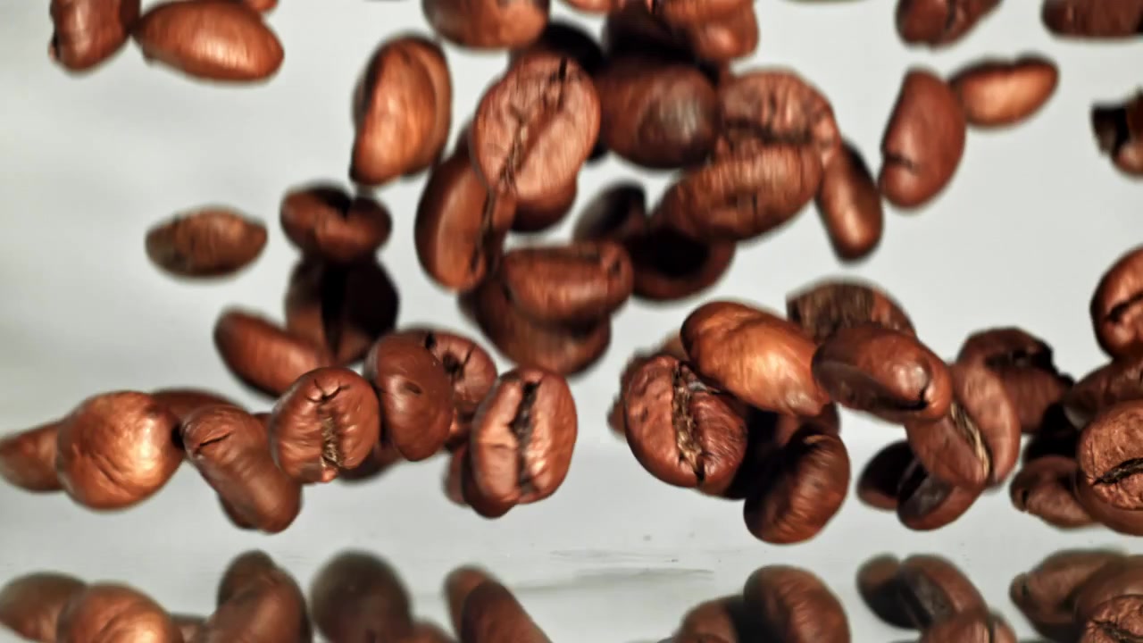 Primo piano di chicchi di caffè tostati che cadono al rallentatore