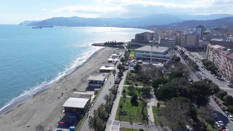 the coast of savona, with beach, palms, and modern city buildings, aerial view