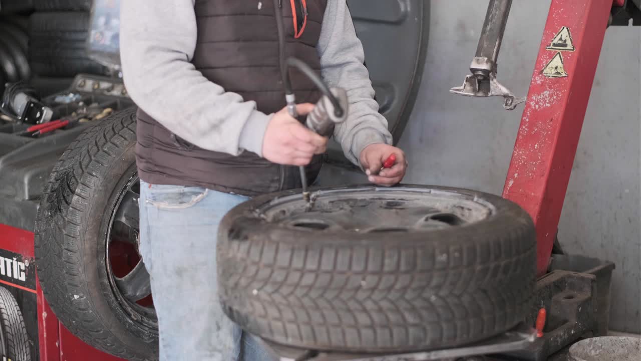 técnico de inflado de neumáticos de automóviles con inflador.