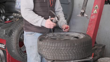 técnico de inflado de neumáticos de automóviles con inflador.