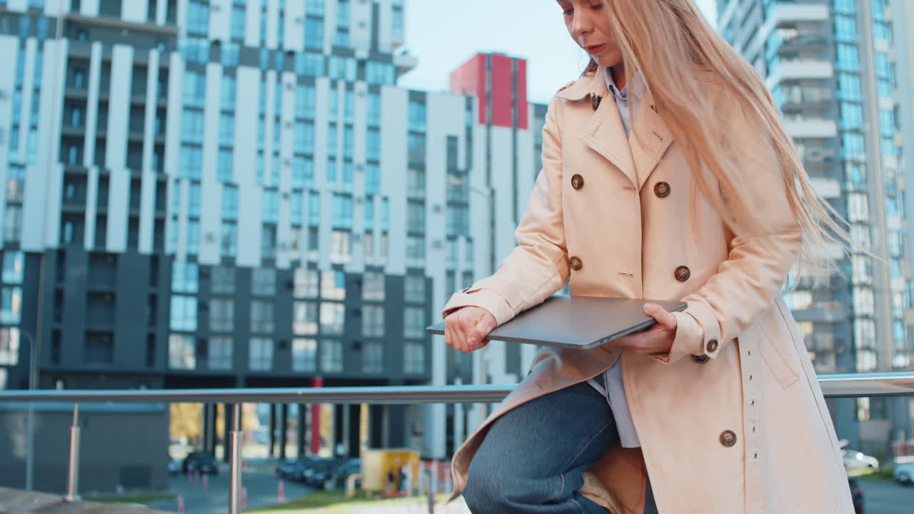 Mature caucasian businesswoman freelancing remotely working on laptop netbook in downtown city area