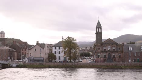 plano panorámico del campanario de la iglesia a lo largo del río ness con colinas en el fondo en inverness, escocia en las tierras altas