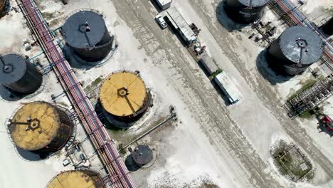 overhead drone shot of large industrial factory with oil storage tanks being prepared for refining