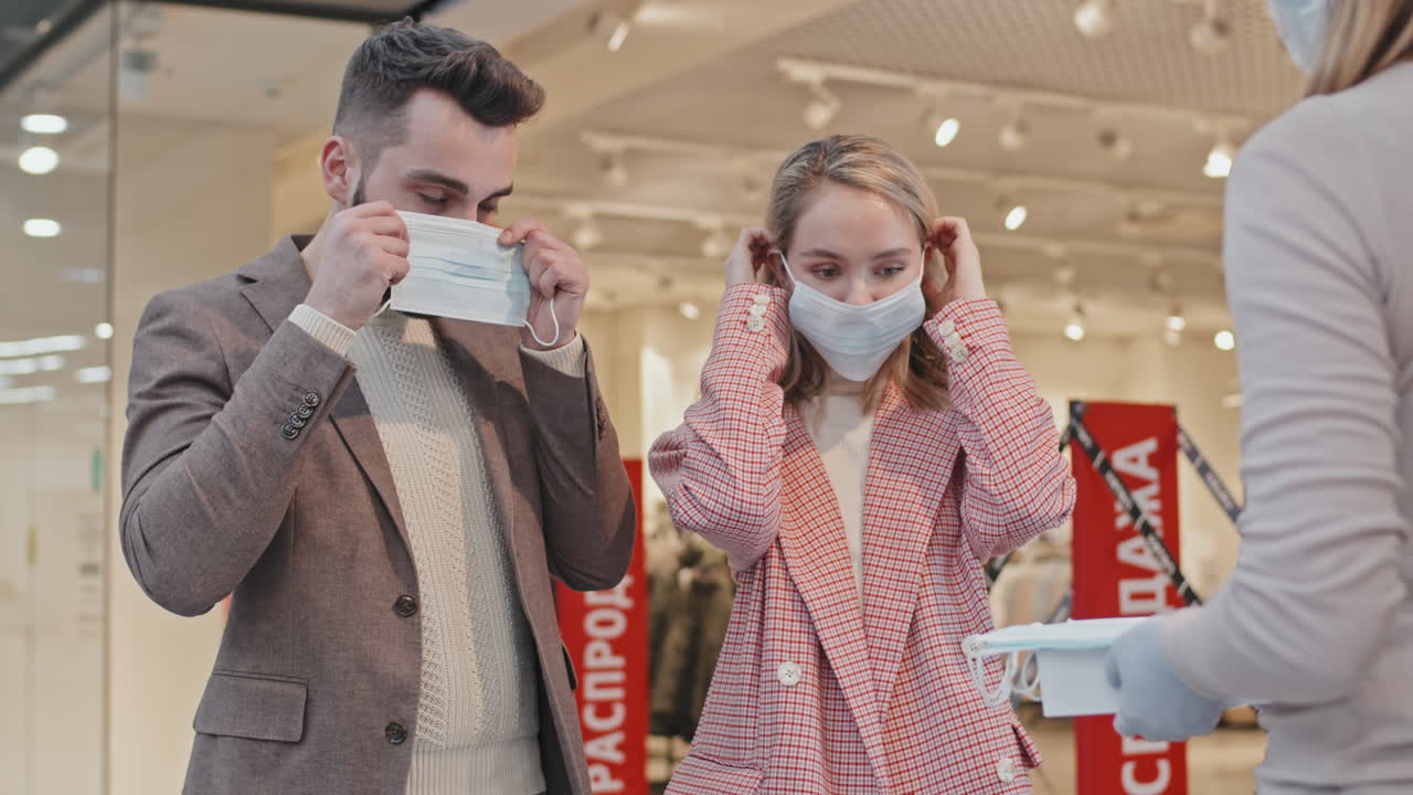 Clothing Store Worker Giving Face Masks To Customers