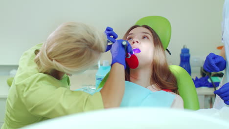 stomatologist using lamp for polymerization of dental materials