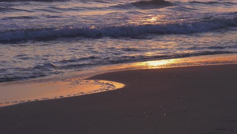 Olas-Del-Océano-En-La-Playa-Del-Amanecer-Rodando-Hacia-La-Orilla-Arenosa-Al-Amanecer,-Cámara-Lenta,-Costa-Mediterránea,-España