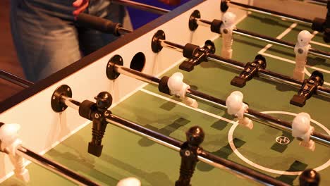 players engaged in a fast-paced foosball game