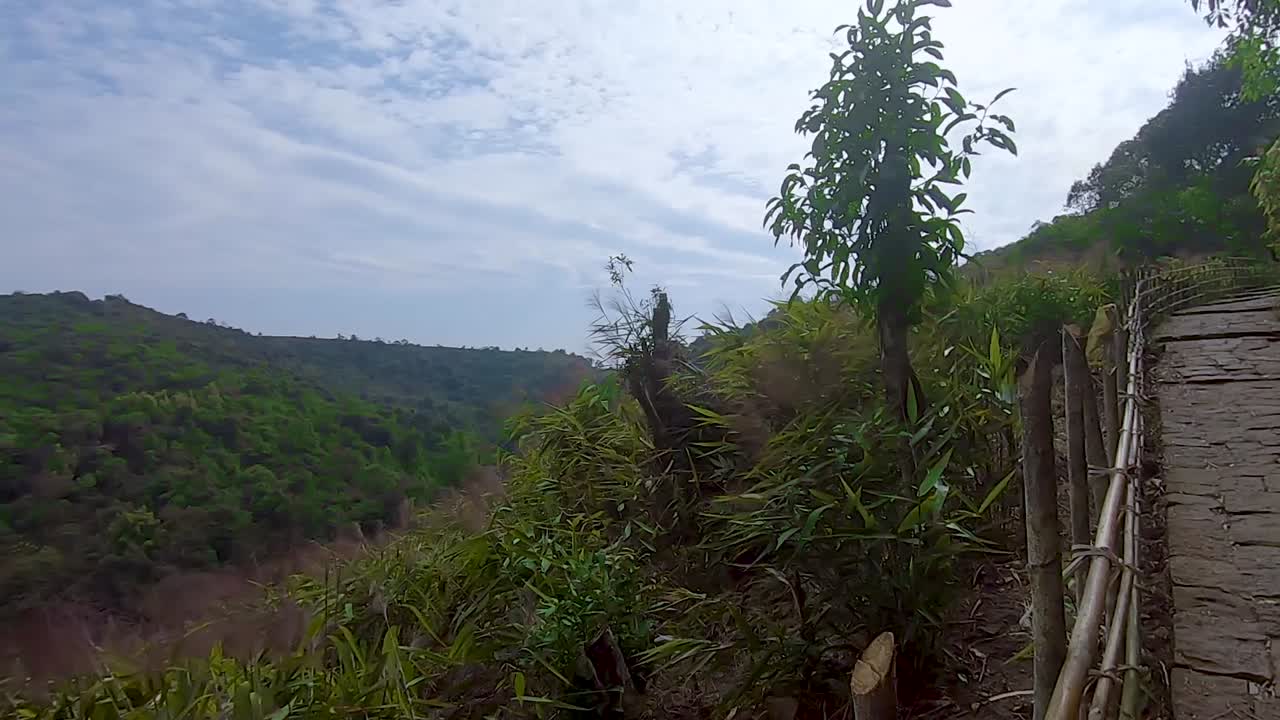 Fitte foreste verdi con una cascata incontaminata e sentieri escursionistici di giorno da un'angolazione piatta, il video è stato girato alle cascate di Krang Suri, Meghalaya, India nord-orientale.