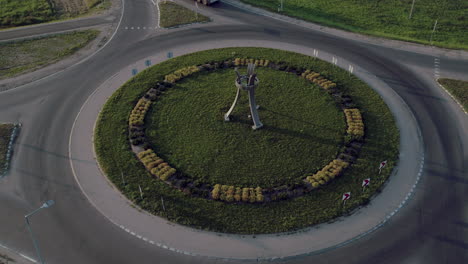 drone shot above a roundabout with a truck and a car