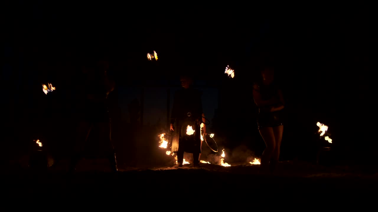 Slow motion: Professional fire performance three women with torches and a man with flamethrowers