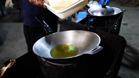 pouring oil into a pan for cooking