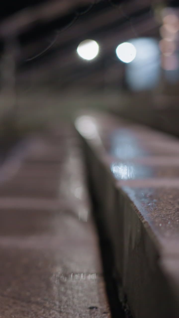 차가 지나가는 흐릿한 배경을 가진 은 계단 계단과 밤에 스테인리스 스 드레일의 뒤쪽 시각