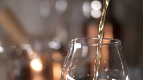 Slow-Motion-Close-up-of-craft-Beer-being-poured-in-to-a-tulip-glass,-bar-background,-copy-space