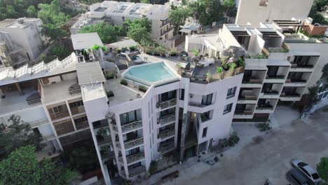 aerial view of modern apartments with a rooftop pool and solar plates