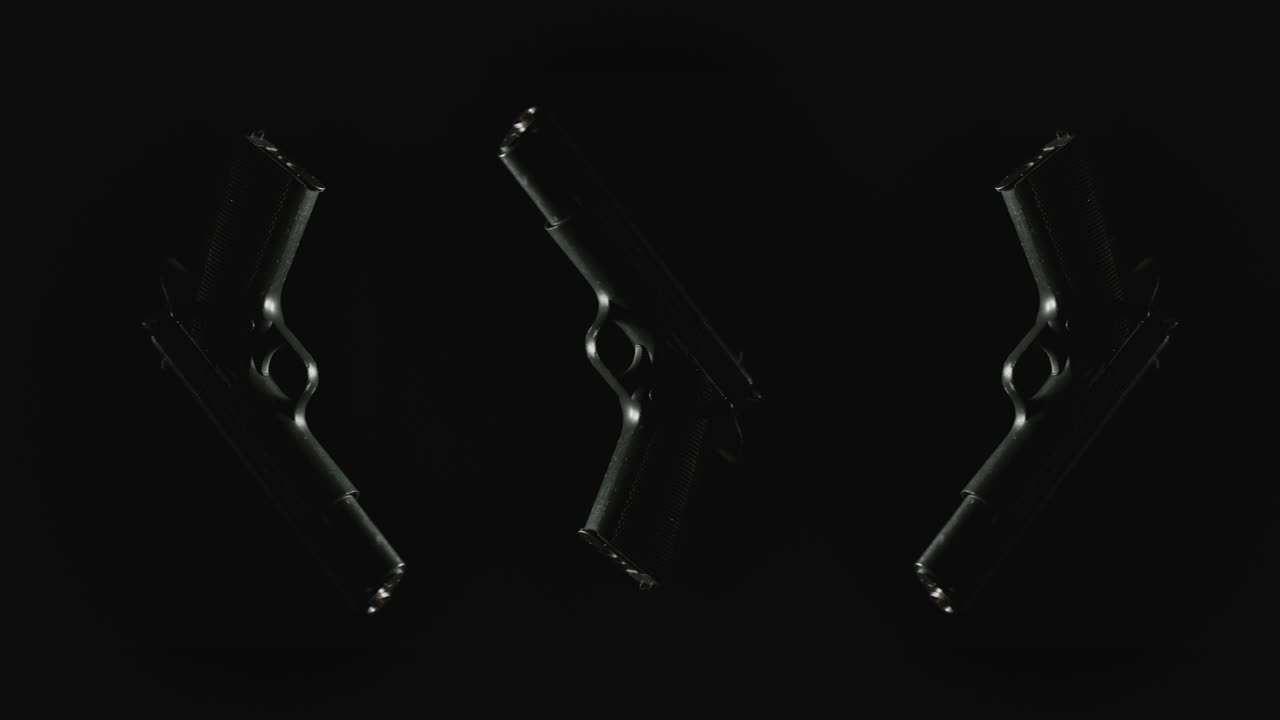 Three pistols on the dark background rotate in slowmotion