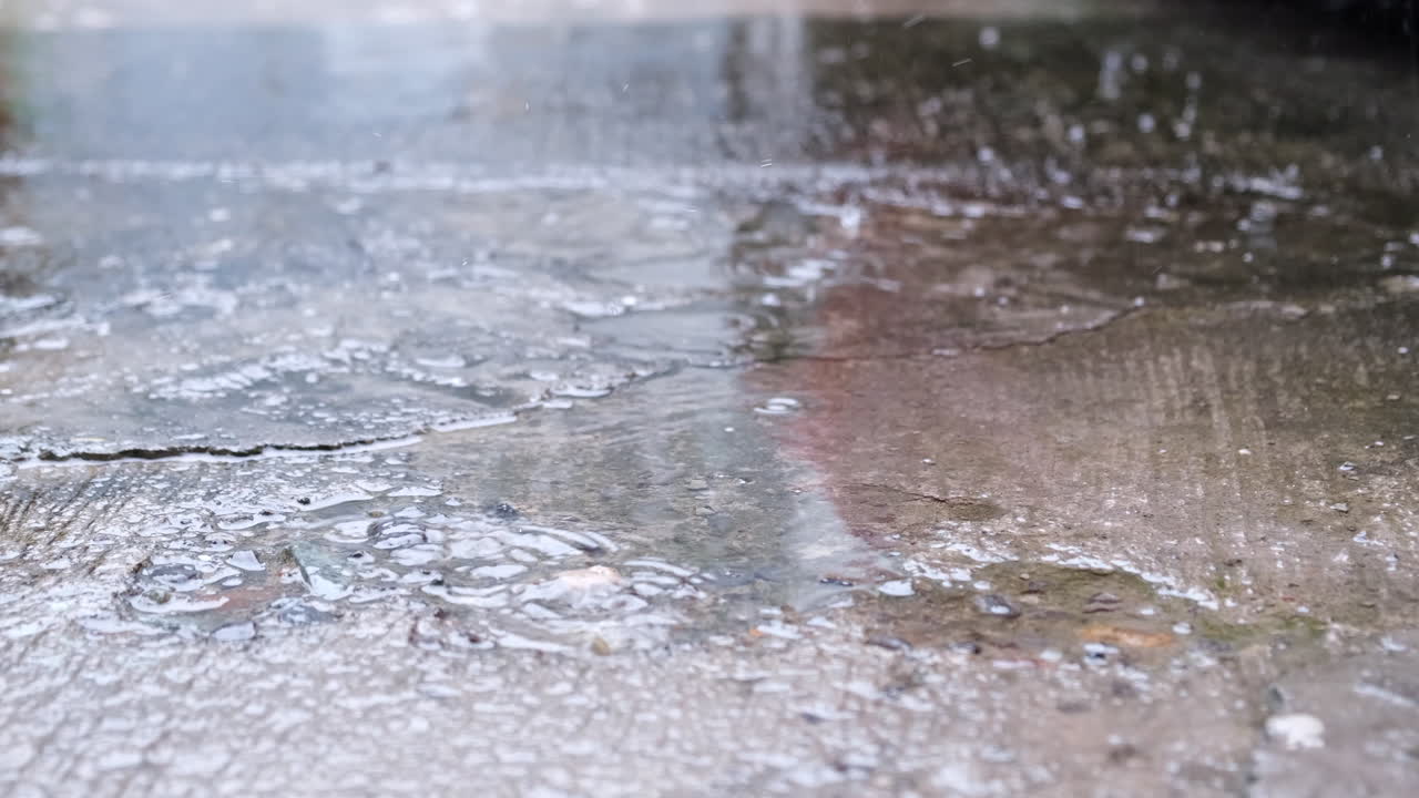 Rain Falling On Asphalt With Puddle. close up