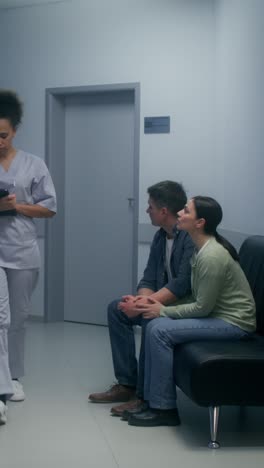 hospital waiting room scene with patients and nurse