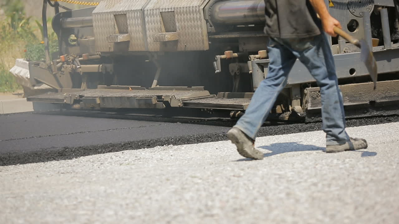 Road rollers leveling fresh asphalt pavement
