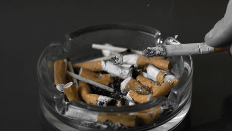 Hand-tipping-ash-from-cigarette-into-ashtray