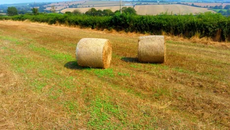 low aerial orbit around two golden bales