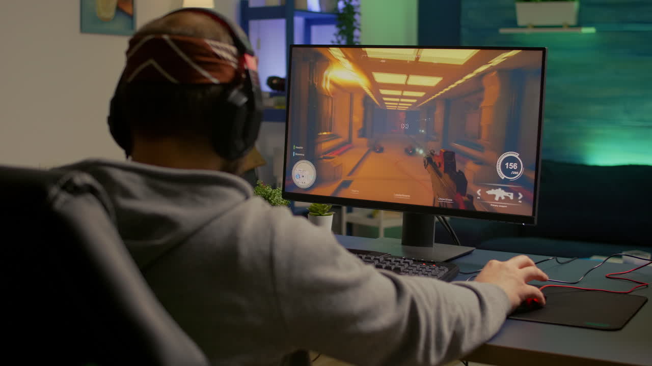 Back of pro gamer playing first person shooter video game