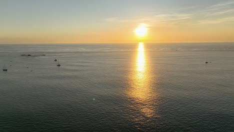 golden sunset over the ocean with sailboats