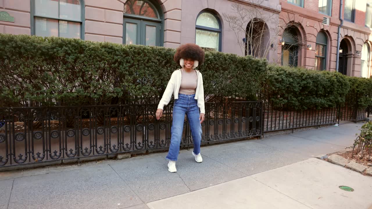 Donna con afro e paraorecchie in strada